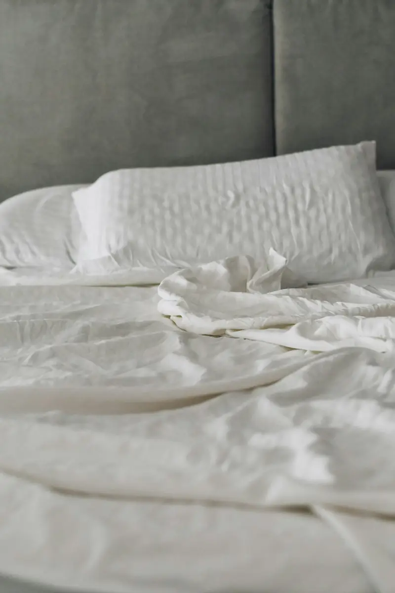 Cama con sábanas blancas de algodón