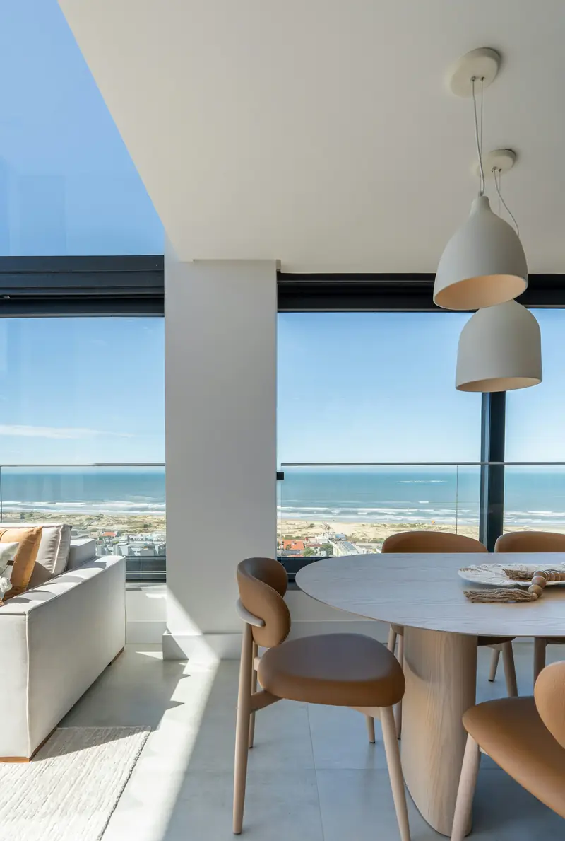 Salón luminoso con mesa de comedor y vistas al mar