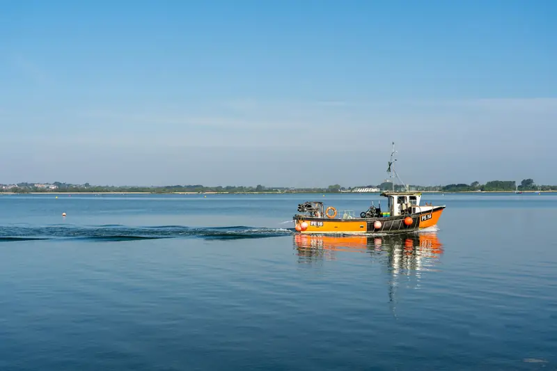 Barca de pesca amarilla en el mar en calma