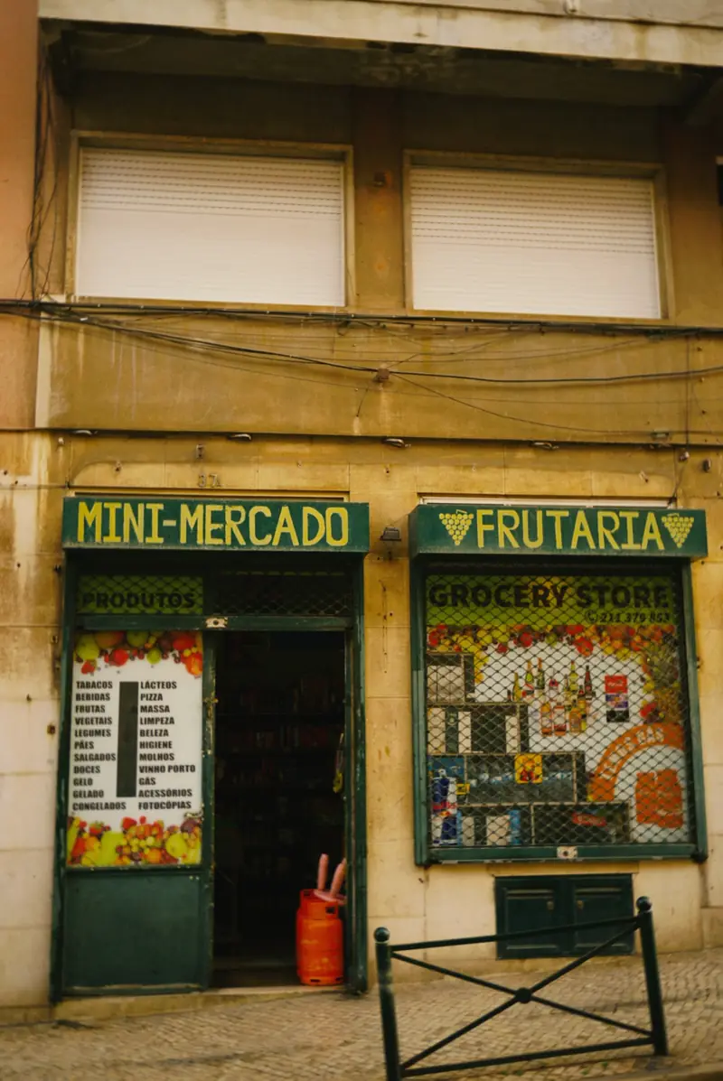 Fachada de la tienda con las puertas abiertas y el cartel de minimercado y frutería